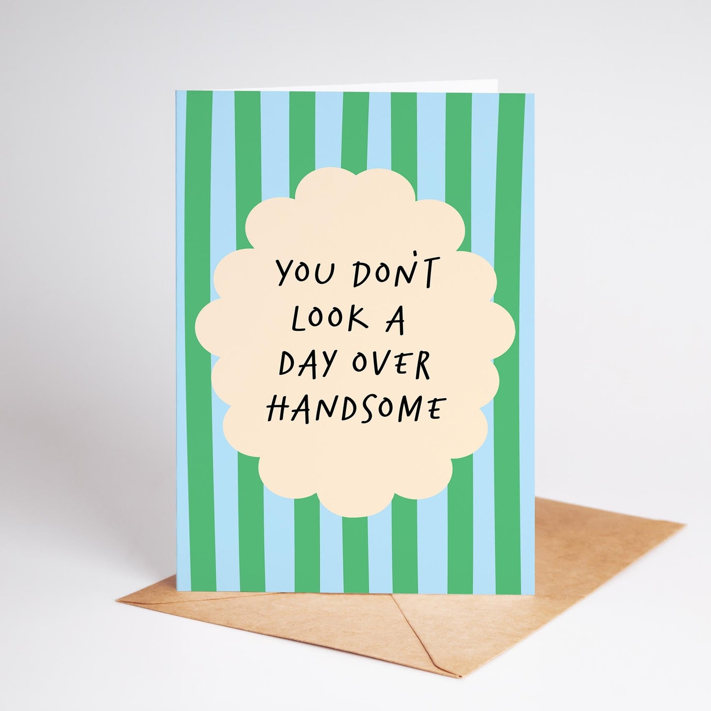 Card with green and blue striped background and text 'You don't look a day over handsome' on a white background.
