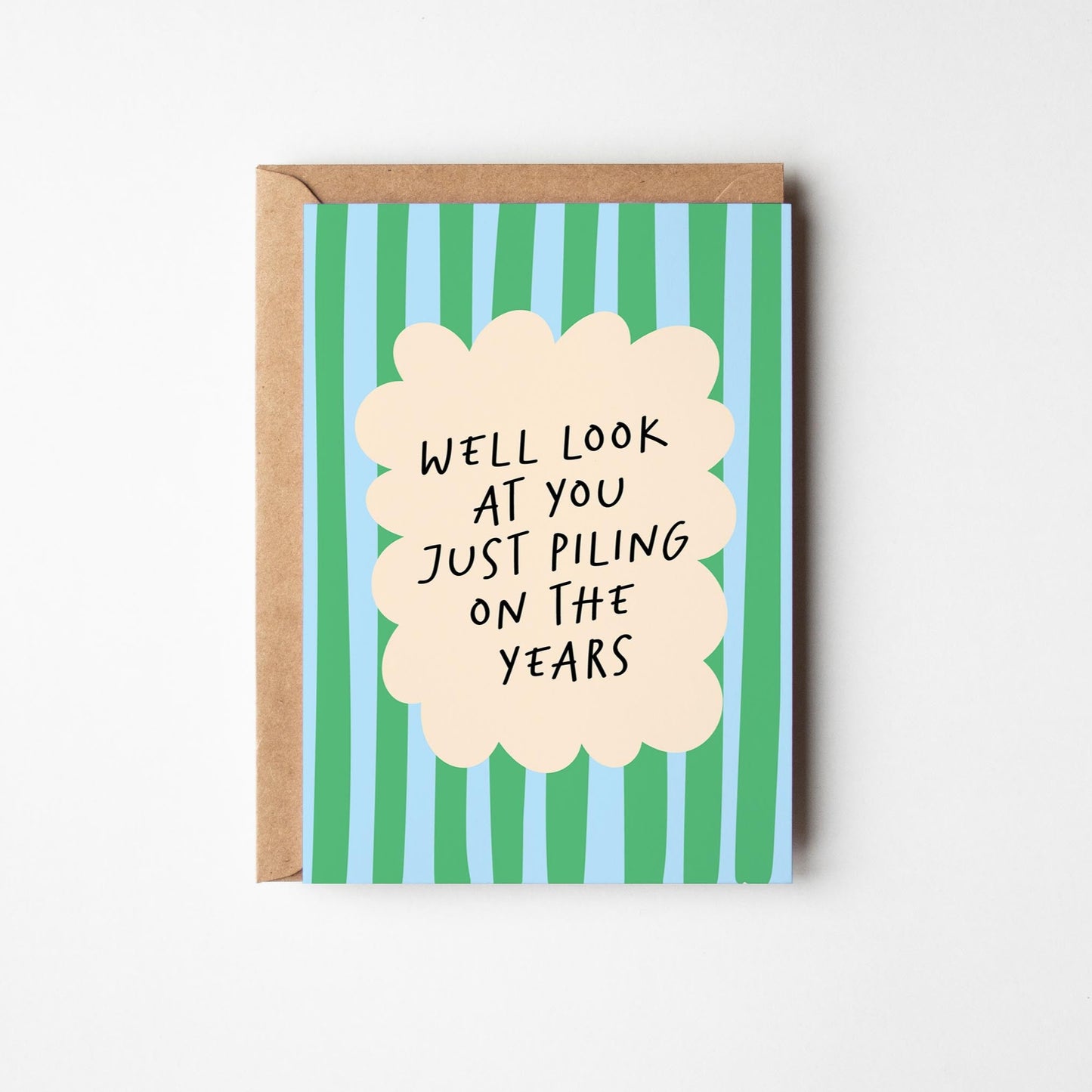 Greeting card with text 'Well look at you just piling on the years' on a striped background