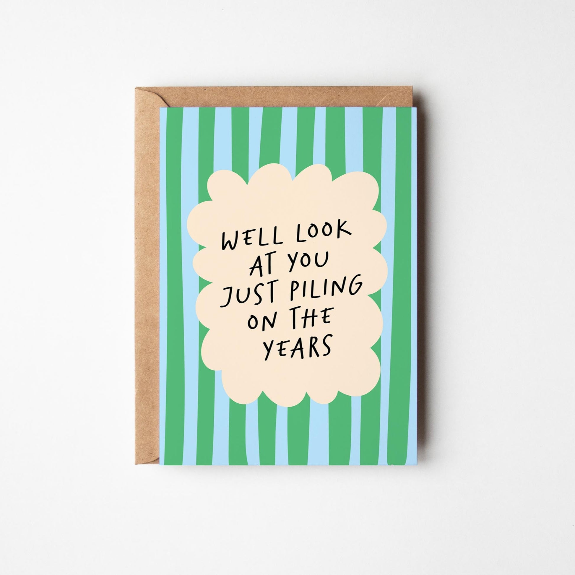 Greeting card with text 'Well look at you just piling on the years' on a striped background