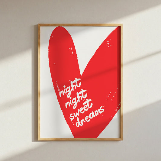 Framed artwork with a red heart and 'night night sweet dreams' text on a white wall.
