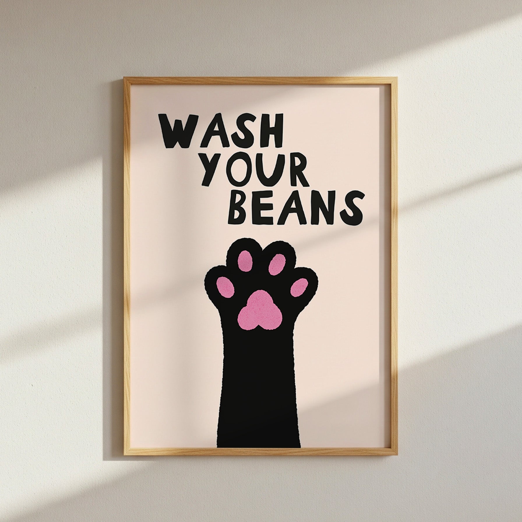 Framed artwork with a paw print and text 'Wash Your Beans' on a light background